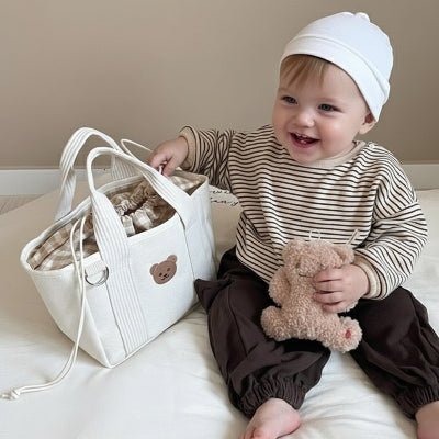 sac a langer bjorn enfant souriant tenant sac